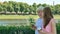 Happy elderly woman and young woman walks along the waterfront using smartphone and drinking coffee. Adult Mother and