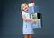 Happy elegant child on grey holding pile of Christmas giftes