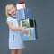 Happy elegant child on grey holding pile of Christmas giftes