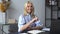 Happy elegant middle aged professional business woman sitting at desk in office.