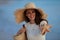 Happy elegant woman on ocean coast at sunset showing starfish