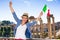 Happy elegant woman in Rome with Italian flag rejoicing