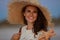 Happy elegant woman with starfish on ocean shore at sunset