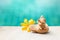 Happy elephant clay sitting on hand sculpture with yellow flower over blurred blue water background