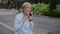 Happy emotional Caucasian old female businesswoman senior excited woman talking mobile phone in city smartphone call