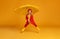 Happy emotional cheerful child boy jumping and laughing  with red umbrella   on colored yellow background