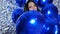 Happy emotional women with blue balloons on background shiny wall decorated with foil