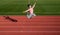 Happy energetic girl child jump on running track, athletics