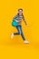 Happy energetic teenage girl jumping after school yellow background, school. Back to school