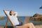 Happy entrepreneur with a laptop relaxing on the beach