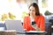 Happy entrepreneur using multiple devices in a coffee shop