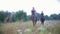 Happy equestrian riders on horseback galloping through the field