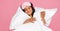 Happy ethnic woman hugging pillows