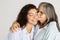 Happy european elderly woman hugging, kissing millennial lady