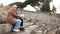 Happy European senior man and young woman sitting on old amphitheater ruins in Ostia, Italy with a map and smartphone.