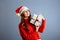 Happy europian Santa Woman is smiling and holding Gift Box for Christmas or New Year. Isolated on gray background