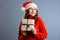 Happy europian Santa Woman is smiling and holding Gift Box for Christmas or New Year. Isolated on gray background