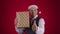 Happy excited 40s man in Santa hat catching flying gift box and shows thumb up