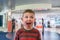 Happy and excited boy in front of a store eager to go in shopping. Making funny face.