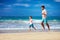 Happy excited father and son running on summer beach, enjoy life