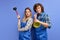 Happy excited female and male plumber dressed in blue uniform with plunger, being glad to repair bathtub
