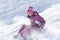 Happy and excited girl Sledding downhill on a snowy day