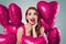 Happy excited model girl portrait. Pretty woman with bright pink heart balloons