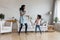 Happy excited mom and active daughter kid dancing to music