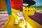 Happy excited toddler baby boy sliding in colorful playground at summer day