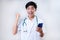 Happy Excited Young Asian doctor man success doing wining gesture holding a mobile phone