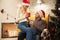 Happy exited blonde woman in Santa`s hat holding gift box while