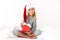 Happy exited little girl in Santa`s hat holding gift box, lookin