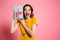 Happy exited pretty girl in yellow dress holding present, looking at camera