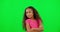 Happy, face and child in a studio with green screen posing in a casual, trendy and stylish kids outfit. Happiness, smile