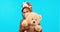 Happy, face and a child with a teddy bear on a blue background for playing, fun and childhood. Smile, playful and