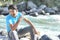 A happy face guy sitting near river lake and enjoying the manali road trip