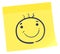 Happy face sticker. Yellow sticky note with doodle