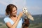 Happy falconer caressing an owl in nature