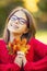 Happy fall girl smiling and joyful holding autumn leaves. Beautiful young girl with maple leaves in red cardigan