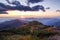 Happy fall. There is a girl standing in sport clothes watching the mountains, majestic sunset, sky with clouds.