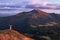 Happy fall. There is a girl standing in sport clothes watching the mountains, majestic sunset, sky with clouds. Tourist place.