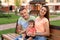 Happy family with adorable little baby on bench