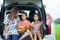 Happy family asian children and their mother playing guitar and singing a song together in a car trunk