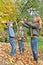 Happy family in autumn forest play with fallen leaf