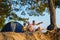 Happy family with backpack and tent looks into the distance