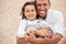 Happy family at beach, father gives kid a hug with smile on her face and laughing with dad. A summer getaway, traveling