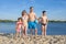 Happy family on the beach by the river. Lifestyle. Sports games on a sunny day