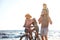 Happy family with bicycle on beach