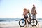 Happy family with bicycle on beach near sea