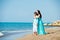 Happy family in a blue dress. Mother with baby on the beach